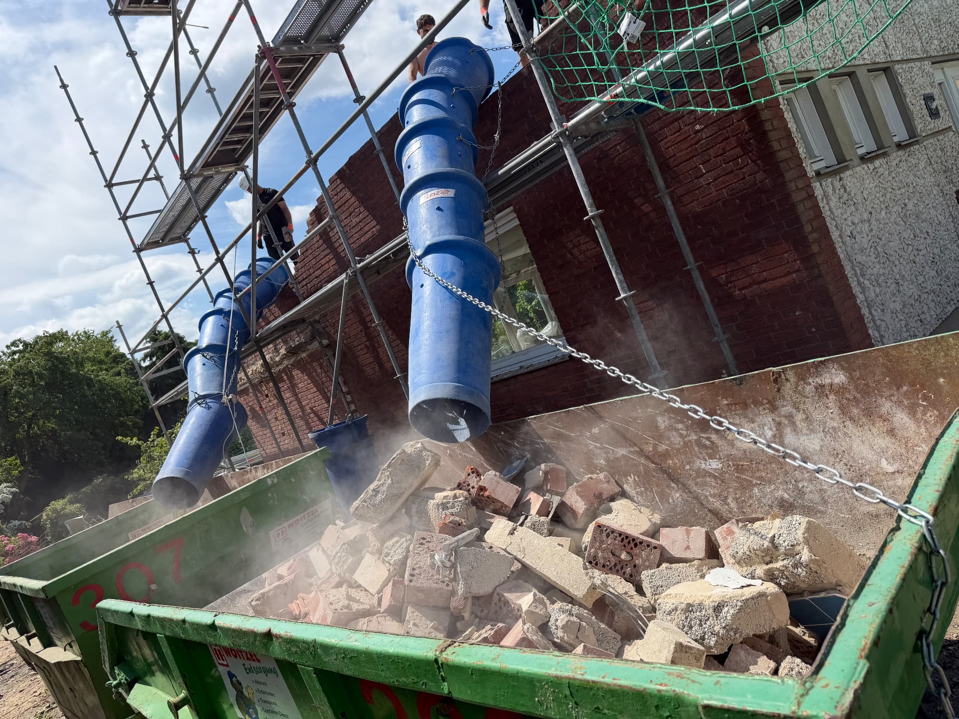 Schutt fällt über die Schuttrutsche direkt in den Container