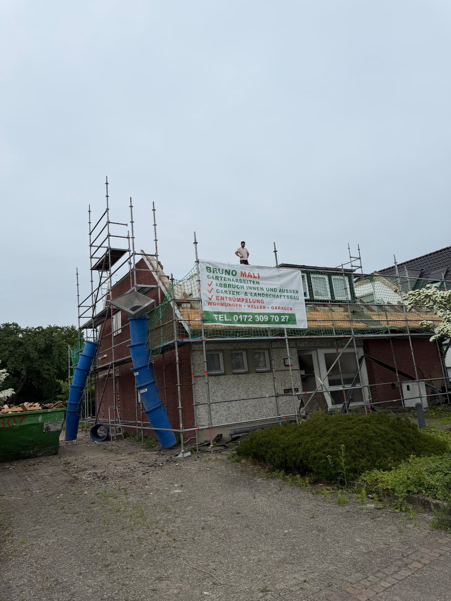 Baustelle mit Gerüst und Firmenbanner